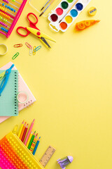 Embark on learning journey with this top-down vertical composition: a charming assortment of colorful school supplies set against an isolated yellow background, with copyspace for text or adverts