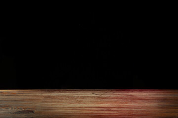 Textured empty wooden table background on black