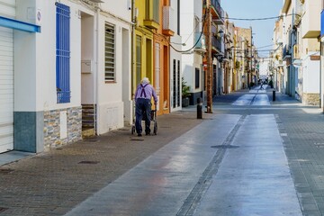 Barcelona, Spain- June 6, 2023. Elderly disabled patient walking slowly with a walker in the...