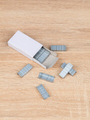 Close up stack of metal staples for stapler on a wooden table