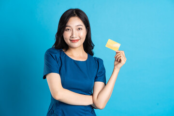 Portrait of beautiful woman in blue dress, isolated on blue background.
