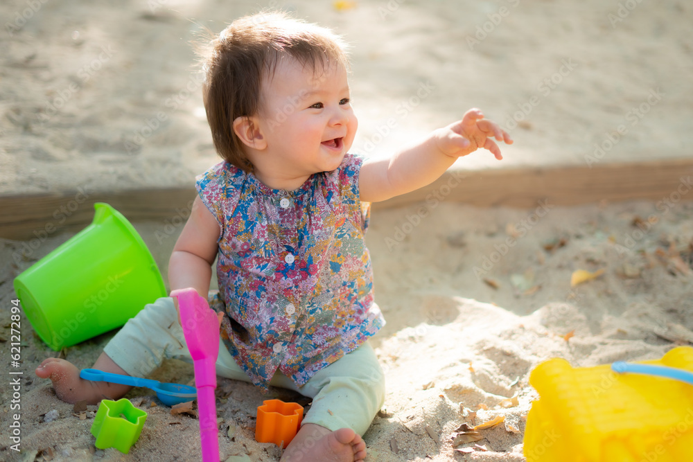 Wall mural adorable 9 months old baby playing outdoors - lifestyle portrait of mixed ethnicity asian caucasian 