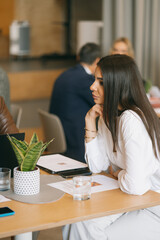 Lovely brunette business girl listening to her colleagues