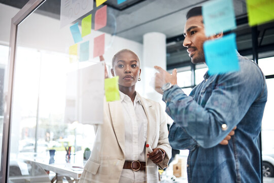 Creative people, thinking and meeting for schedule planning, brainstorming or team strategy at the office. Man and woman in teamwork decision for project plan, tasks or sticky note ideas in startup - Powered by Adobe