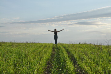 jovem mulher de braços abertos em campo paisagem rural de plantação