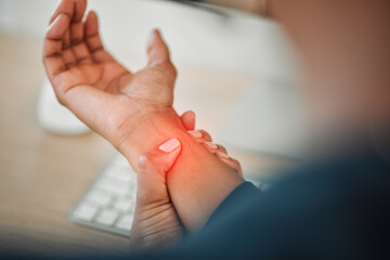 Hands, business or person with wrist pain while working on a computer in office workplace with red glow or injury. Hurt, carpal tunnel syndrome or closeup of injured worker with discomfort arm cramp