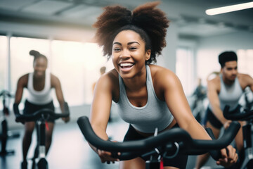 Group fitness class , featuring participants engaged in an energetic workout, such as spinning,...