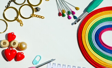 Bright rainbow palette of multi-colored, cotton threads, hooks and accessories isolated on a white background.