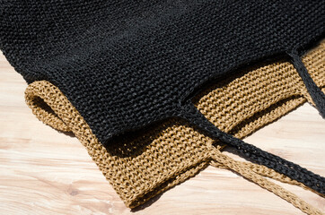 Two women's bags made of raffia black and beige.