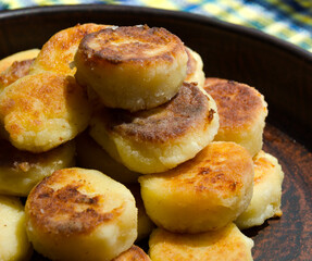 Homemade cheesecakes are fried in a pan.