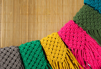 Small handbags knitted with macrame technique on a bamboo background.