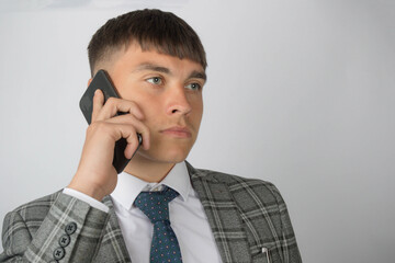 Young entrepreneur wearing a suit and tie making a phone call