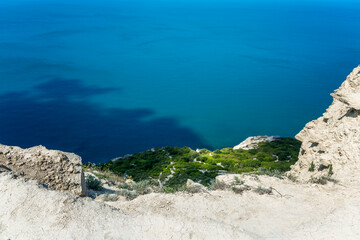 High cliff on the turquoise sea. Great look. Tourism, travel and active lifestyle.
