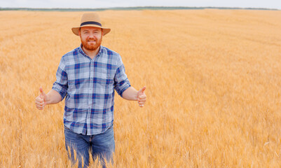  Happy farmer Standing plant in his Wheat field.Peasant farmer standing, cultivating wheat in the...