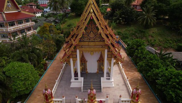 Filming of Karon Wat Suwan Khiri Khet temple, scenery, traditions, Buddhism. Aerial view of a beautiful temple, golden decorations, roofs and nature of Phuket island, culture and religion of Thailand