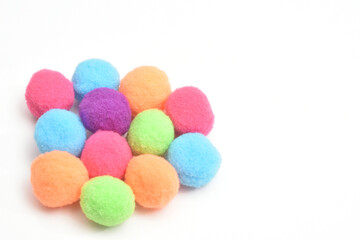 白背景に並んだカラフルな手芸用のポンポン（フェルトボール）、端に集合