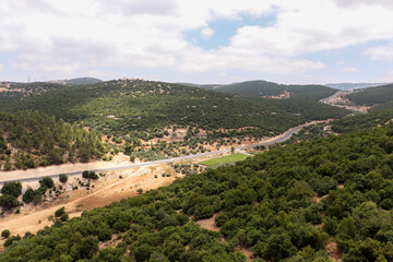 Fototapeta na wymiar Ajloun, Jordan : An aerial view of the forests, trees, mountains of Ajloun, its streets and roads taken from the Ajloun cable car