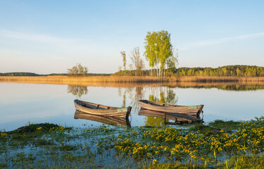 two wooden fishing boats in the lake .