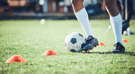 Soccer player, feet and ball with training cone on a field for sports game and fitness. Legs or shoes of male football or athlete person outdoor for agility exercise, performance or workout on grass