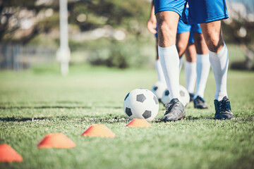 Feet, soccer player and ball with training cone on a field for sports game and fitness. Legs or...