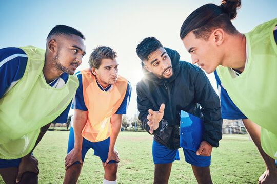Soccer player, team talk and coach on field for tactics, sport and listen together for training, advice or fitness. Athlete men, group and mentor on pitch for exercise, football or teamwork in summer