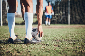 Soccer ball, sports and feet of person to kick on field, fitness training or shoot for a goal in...