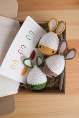 Handmade Easter bunny eggs in a box on a wooden background.