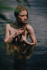 Portrait of naked woman swimming in the lake - 621308259