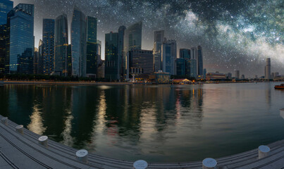 A panoramic image of downtown Singapore during the blue hour with the city lite up and reflecting...