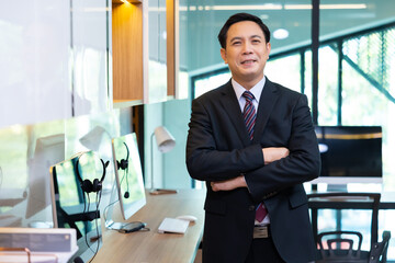 Male crossed arms suit. happy mature Asian man looking at camera. Portrait of Confident successful business people woking in home office