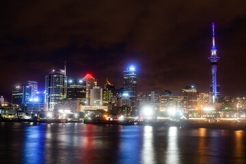 Obraz premium Night city of Auckland New Zealand. Glowing skyscrapers, bay and seaport of Auckland.