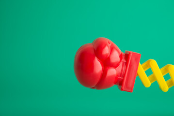 Red boxing glove fist punching toy on green background copy space. Concept of special offer boxing...