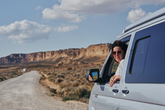 Femme à la fenêtre dans van dans le desert