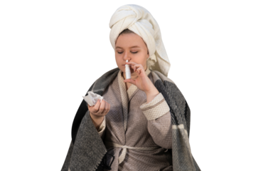 A girl with symptoms of a cold on a transparent background injects a spray into her nose. Runny nose and allergies. The concept of medicine, pharmacy, healthcare and home treatment