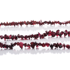 Strung garnet natural stones strings on white background. Energy crystals. Healing gemstones....