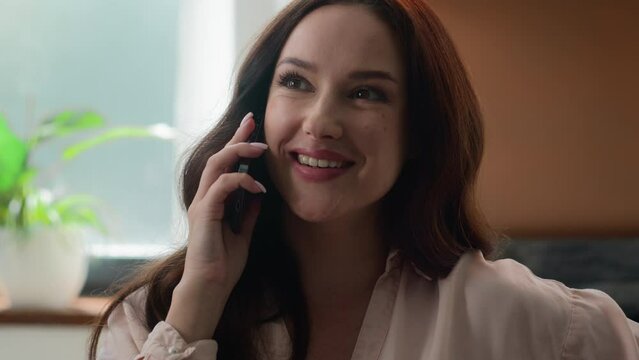 Caucasian businesswoman beautiful girl healthy millennial woman female client smiling laughing talking phone mobile talk business call funny conversation communicate with friends by smartphone indoors