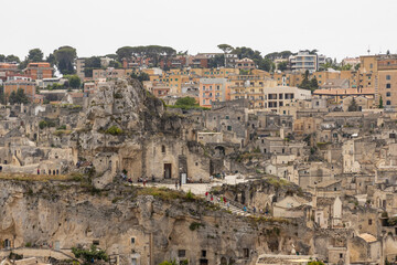 Fototapeta na wymiar View of the city of Matera by day. Typical Salento illuminations during the holidays. Feast of the Brown Madonna, Matera. Prehistoric caves from the Murgia.Mysterious and ancient land among the stones