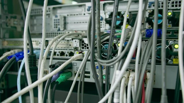 close-up of a pile of network patch cables sorted in a rack cabinet leading from a patch panel in a server rack in a data center room