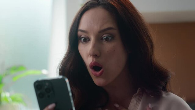 Shocked Caucasian female looking at cellphone read unbelievable astonish news excited girl woman wonder with mobile phone receive smartphone sms amazed say wow shock amazement at home business office