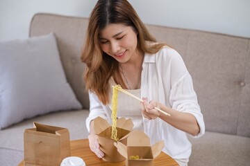 Asian woman with takeaway food and drinks at home. consumption eating home delivery food. enjoying...