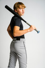 Teenage male baseball player standing casually with bat over his shoulder