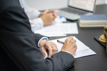 Legal counsel presents to the client a signed contract with gavel and legal law. justice and lawyer concept