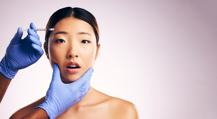 Asian woman, hands and needle for plastic surgery in studio for cosmetics, mockup space or collagen on a white background banner. Beauty, doctor and syringe for patient, change with pain on face