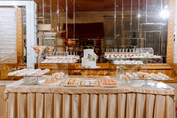 Festive dessert table with sweets. Wedding candy bar, various cakes, chocolates on stands.
