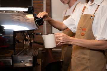 Barista pouring coffee into a cup in coffee shop, closeup