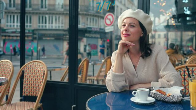 Portrait of a beautiful girl sitting at a table in a cafe in Paris