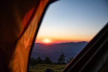 Sunrise seen from a tent in the mountains. The sun rises over Babia Gora - the highest mountain in the Zywiecki Beskids in Poland, viewed from Mount Pilsko.