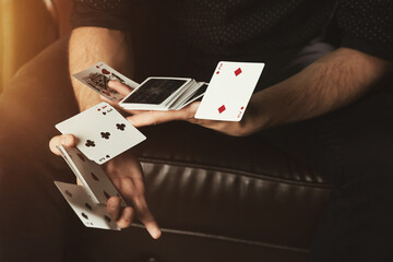 Close-up of gambler guy clever hands of magician  gambling cards. Male showing perform trick of playing cards. Concept of magic, casino, performance, circus, gambling, game, show. Copy ad text space