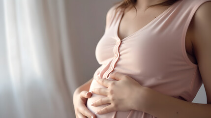 Pregnant woman in dress holds hands on belly on a white background. Close up cropped of pregnant woman in green dress touching caressing belly, expecting first baby child