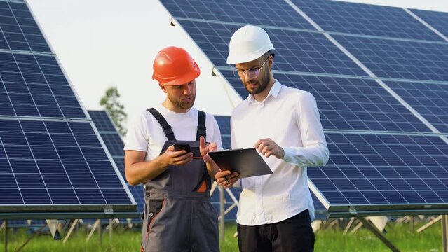 Two technical engineers review plan on paper and discuss